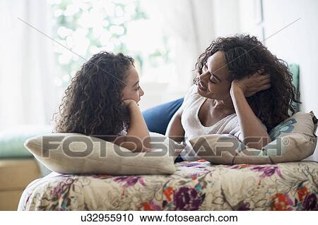 Mother with daughter (8-9) talking on bed View Large Photo Image Stock Image - Mother with daughter (8-9) talking on bed. Fotosearch