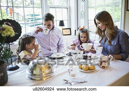 Parents and daughter (4-5) eating together in dining room View Large Photo Image Picture - Parents and daughter (4-5) eating together in dining room. Fotosearch