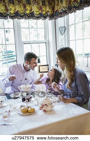 Parents and daughter (4-5) eating together in dining room View Large Photo Image Stock Photography - Parents and daughter (4-5) eating together in dining room. Fotosearch