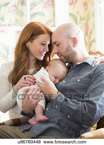 Stock Photo - Parents holding their sleeping baby (2-5 months) . Fotosearch