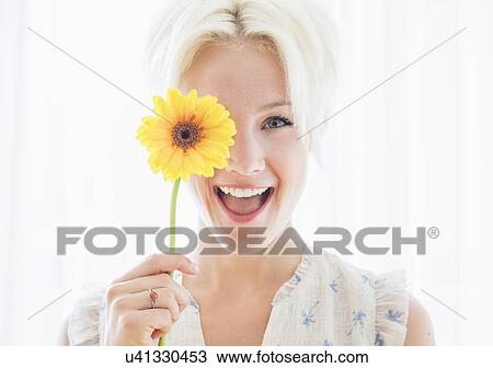 Portrait of blonde woman holding yellow flower View Large Photo Image Stock Image - Portrait of blonde woman holding yellow flower. Fotosearch