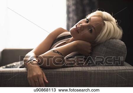 Portrait of blonde woman relaxing on sofa View Large Photo Image Stock Image - Portrait of blonde woman relaxing on sofa. Fotosearch