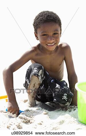 Portrait of boy (4-5) playing on beach View Large Photo Image Picture - Portrait of boy (4-5) playing on beach. Fotosearch