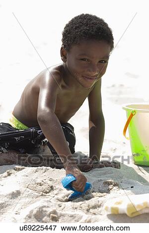 Portrait of boy (4-5) playing on beach View Large Photo Image Stock Photo - Portrait of boy (4-5) playing on beach. Fotosearch