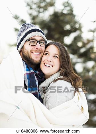 Portrait of couple wrapped in blanket smiling outdoors View Large Photo Image Stock Photograph - Portrait of couple wrapped in blanket smiling outdoors. Fotosearch