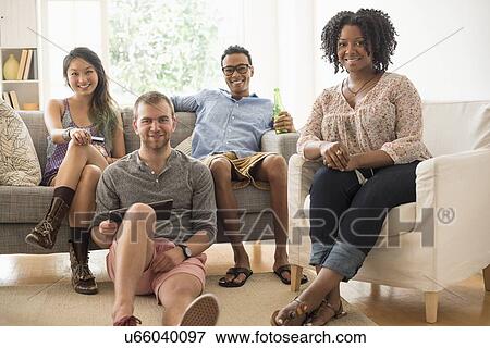 Portrait of group of friends sitting in living room View Large Photo Image Stock Photo - Portrait of group of friends sitting in living room. Fotosearch