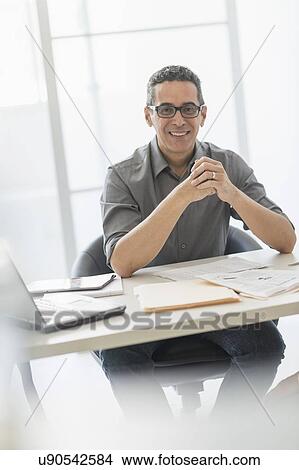Picture - Portrait of man at desk in office. Fotosearch