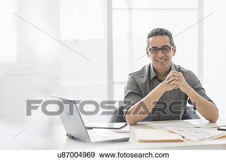Stock Photo - Portrait of man at desk in office. Fotosearch