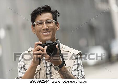 Portrait of man holding camera View Large Photo Image Picture - Portrait of man holding camera. Fotosearch