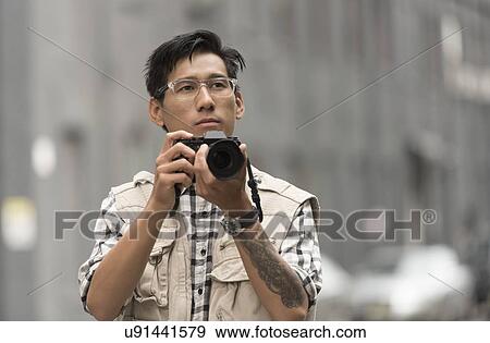 Portrait of man holding camera View Large Photo Image Stock Photo - Portrait of man holding camera. Fotosearch