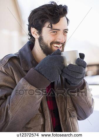 Picture - Portrait of man holding coffee mug outdoors in winter. Fotosearch