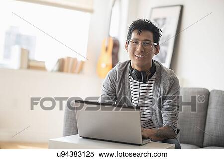 Portrait of man with headphones in front of laptop View Large Photo Image Stock Photography - Portrait of man with headphones in front of laptop. Fotosearch