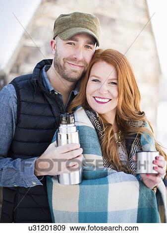 Portrait of mid adult couple having drink from vacuum flask, looking at camera View Large Photo Image Stock Photo - Portrait of mid adult couple having drink from vacuum flask, looking at camera. Fotosearch