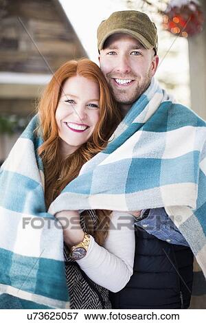 Portrait of mid adult couple wrapped in checked blanket View Large Photo Image Stock Photo - Portrait of mid adult couple wrapped in checked blanket. Fotosearch