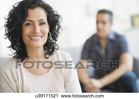 Portrait of smiling woman with man in background View Large Photo Image Stock Image - Portrait of smiling woman with man in background. Fotosearch