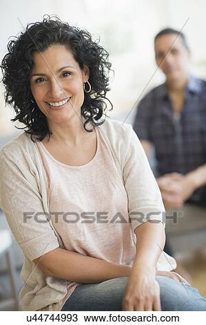 Portrait of smiling woman with man in background View Large Photo Image Stock Image - Portrait of smiling woman with man in background. Fotosearch