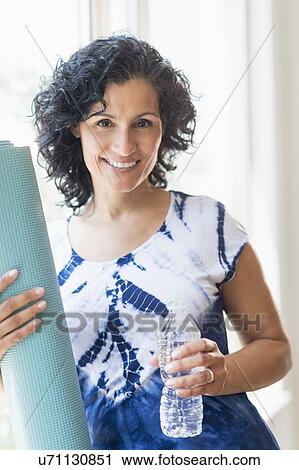 Portrait of smiling woman with yoga mat View Large Photo Image Stock Image - Portrait of smiling woman with yoga mat. Fotosearch