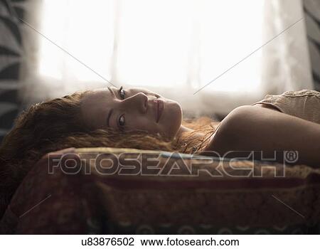 Stock Image - Portrait of stylish woman in bed. Fotosearch