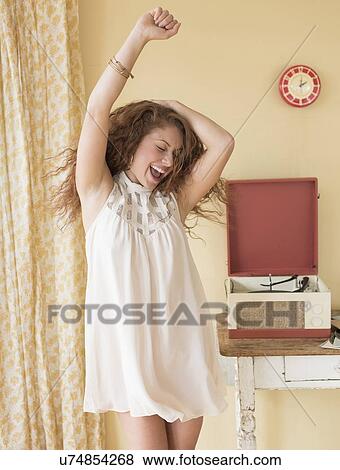 Stock Photo - Portrait of woman dancing happily in room. Fotosearch