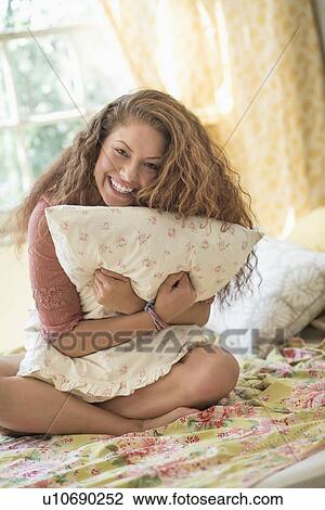 Portrait of woman embracing pillow View Large Photo Image Stock Image - Portrait of woman embracing pillow. Fotosearch