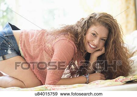 Stock Photo - Portrait of woman kneeling in bed. Fotosearch