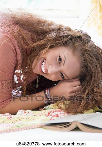 Stock Photo - Portrait of woman lying on bed. Fotosearch