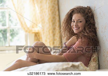 Portrait of woman sitting on bed View Large Photo Image Stock Image - Portrait of woman sitting on bed. Fotosearch