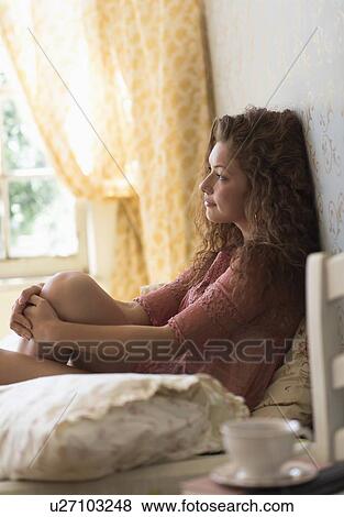 Portrait of woman sitting on bed View Large Photo Image Stock Photo - Portrait of woman sitting on bed. Fotosearch