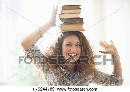 Portrait of woman with books on top of head View Large Photo Image Stock Photo - Portrait of woman with books on top of head. Fotosearch