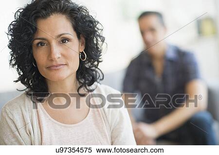 Stock Photography - Portrait of woman with man in background. Fotosearch