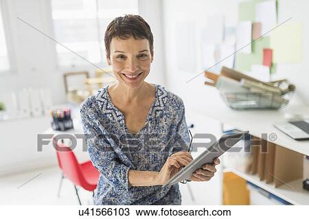 Stock Image - Portrait of woman working in home office. Fotosearch