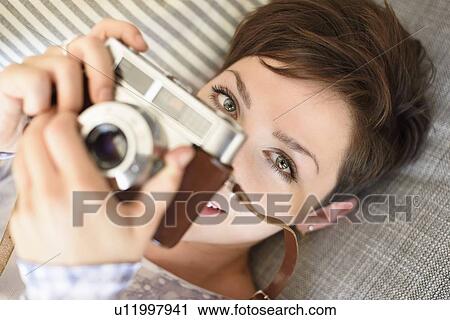 Portrait of young woman holding old fashioned camera View Large Photo Image Stock Image - Portrait of young woman holding old fashioned camera. Fotosearch