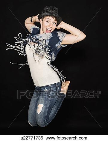 Stock Photograph - Portrait of young woman jumping. Fotosearch