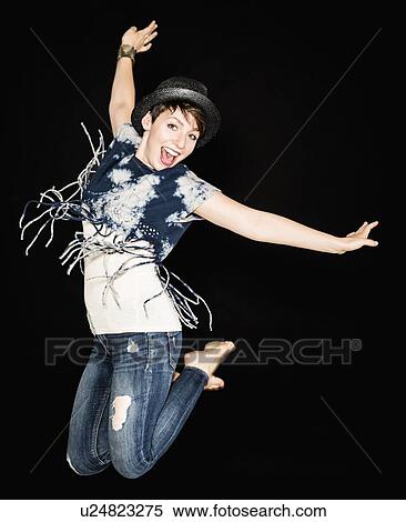 Stock Photography - Portrait of young woman jumping. Fotosearch