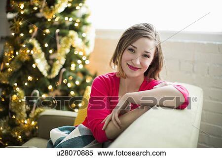 Stock Photography - Portrait of young woman relaxing at Christmas time. Fotosearch