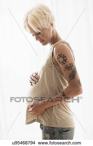 Pregnant woman with hands on stomach View Large Photo Image Picture - Pregnant woman with hands on stomach. Fotosearch