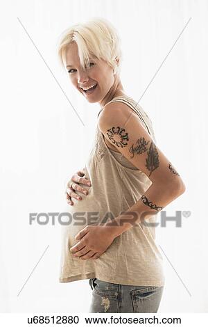 Stock Image - Pregnant woman with hands on stomach. Fotosearch