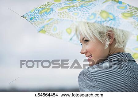 Profile of blonde woman under umbrella View Large Photo Image Picture - Profile of blonde woman under umbrella. Fotosearch