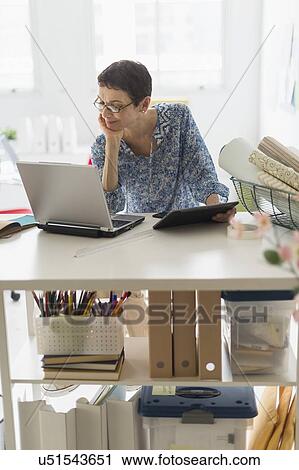 Senior business woman using cell phone and tablet pc in office View Large Photo Image Stock Image - Senior business woman using cell phone and tablet pc in office. Fotosearch