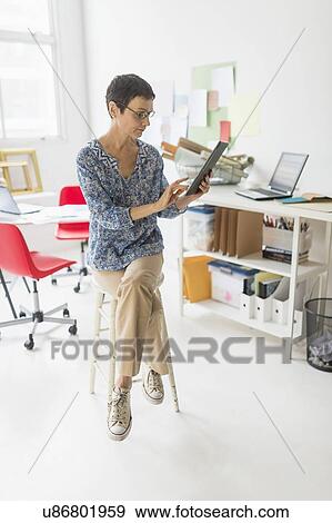 Senior business woman using laptop and tablet in office View Large Photo Image Stock Photo - Senior business woman using laptop and tablet in office. Fotosearch
