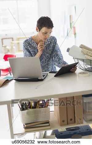 Stock Image - Senior business woman using tablet pc in office. Fotosearch