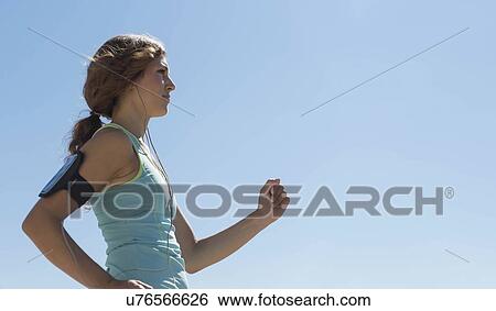 Side view of young woman jogging View Large Photo Image Stock Photograph - Side view of young woman jogging. Fotosearch