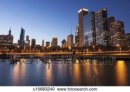 Stock Image - Skyline at dusk seen from marina. Fotosearch