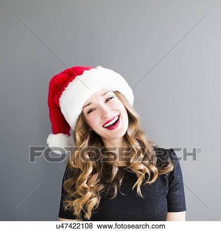 Studio portrait of woman wearing Santa hat View Large Photo Image Stock Photo - Studio portrait of woman wearing Santa hat. Fotosearch