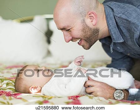 Studio shot of father smiling to his son (2-5 months) View Large Photo Image Stock Image - Studio shot of father smiling to his son (2-5 months). Fotosearch