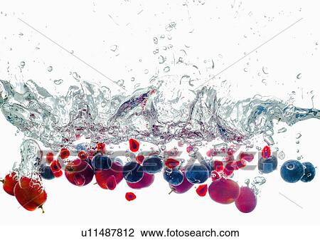 Stock Image - Studio shot of fruits falling into water. Fotosearch