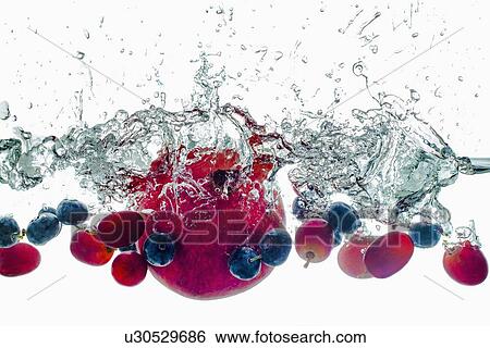 Stock Photograph - Studio shot of fruits falling into water. Fotosearch