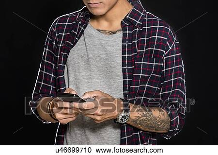 Studio shot of man text messaging View Large Photo Image Stock Image - Studio shot of man text messaging. Fotosearch