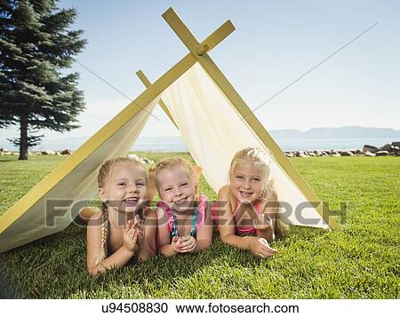 Stock Image - Three girls (2-3, 4-5) playing in tent. Fotosearch