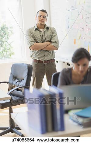 Picture - Two people working in office. Fotosearch
